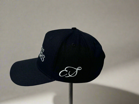 Black cap with white embroidery on a white surface