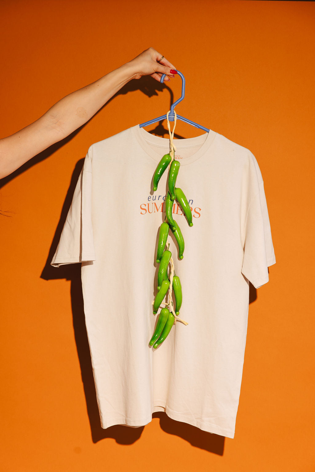 European Summers t-shirt with text on a hanger against an orange background
